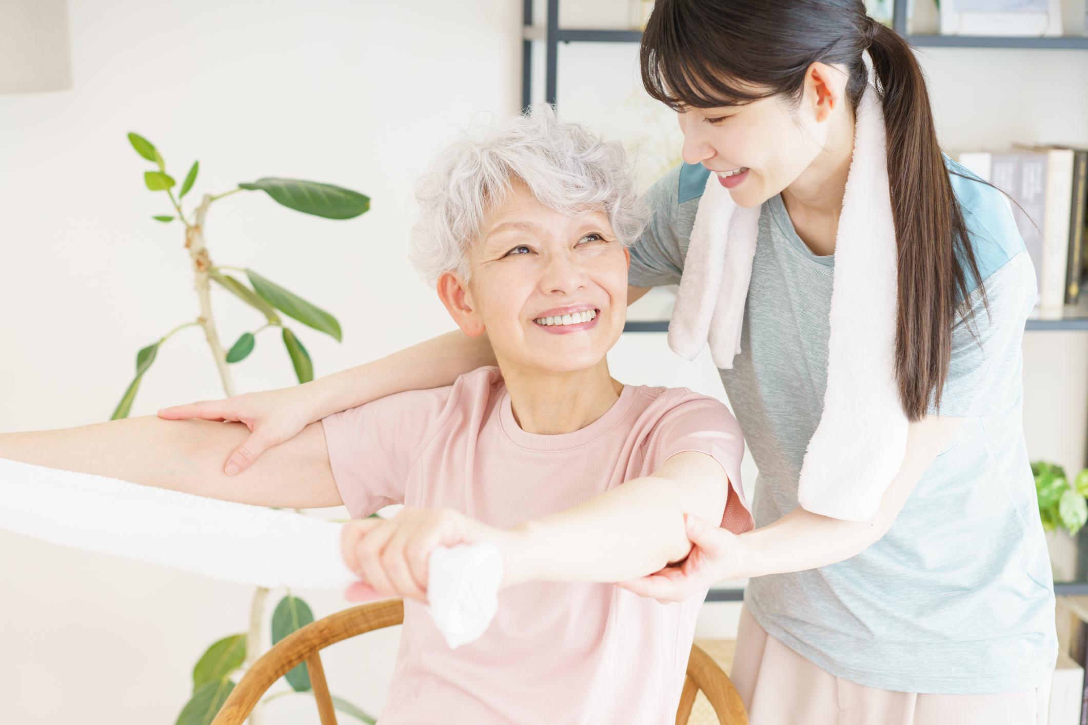 高齢のお母さんと娘さんが一緒に無理のない体操を楽しむ様子